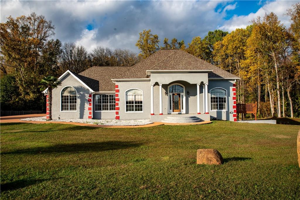 front view of a house with swimming pool and a yard