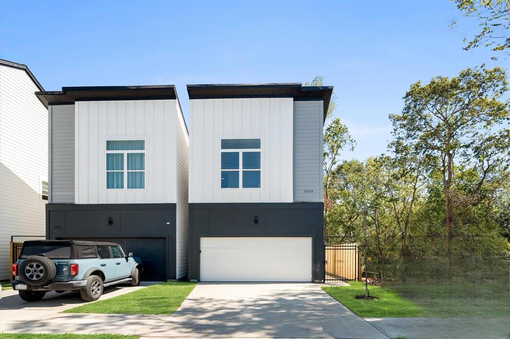 a car parked in front of a house with a yard