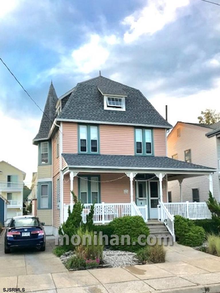 a front view of a house with cars parked