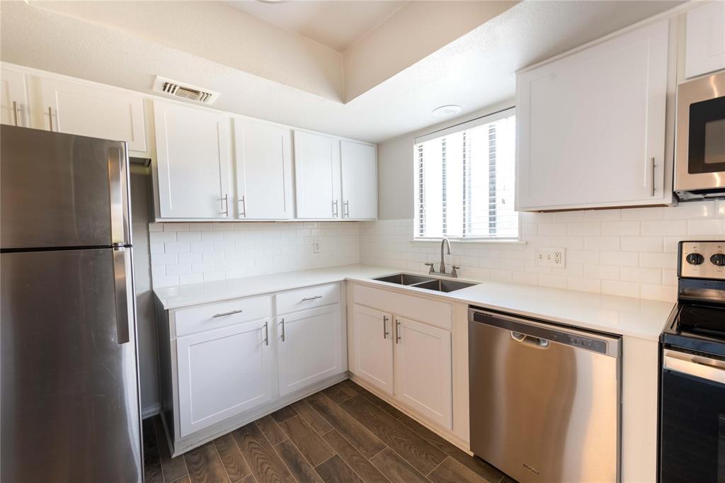 a kitchen with a sink cabinets stainless steel appliances and a window