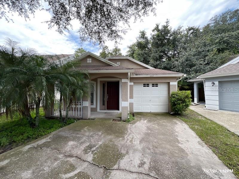 front view of a house with a yard and trees