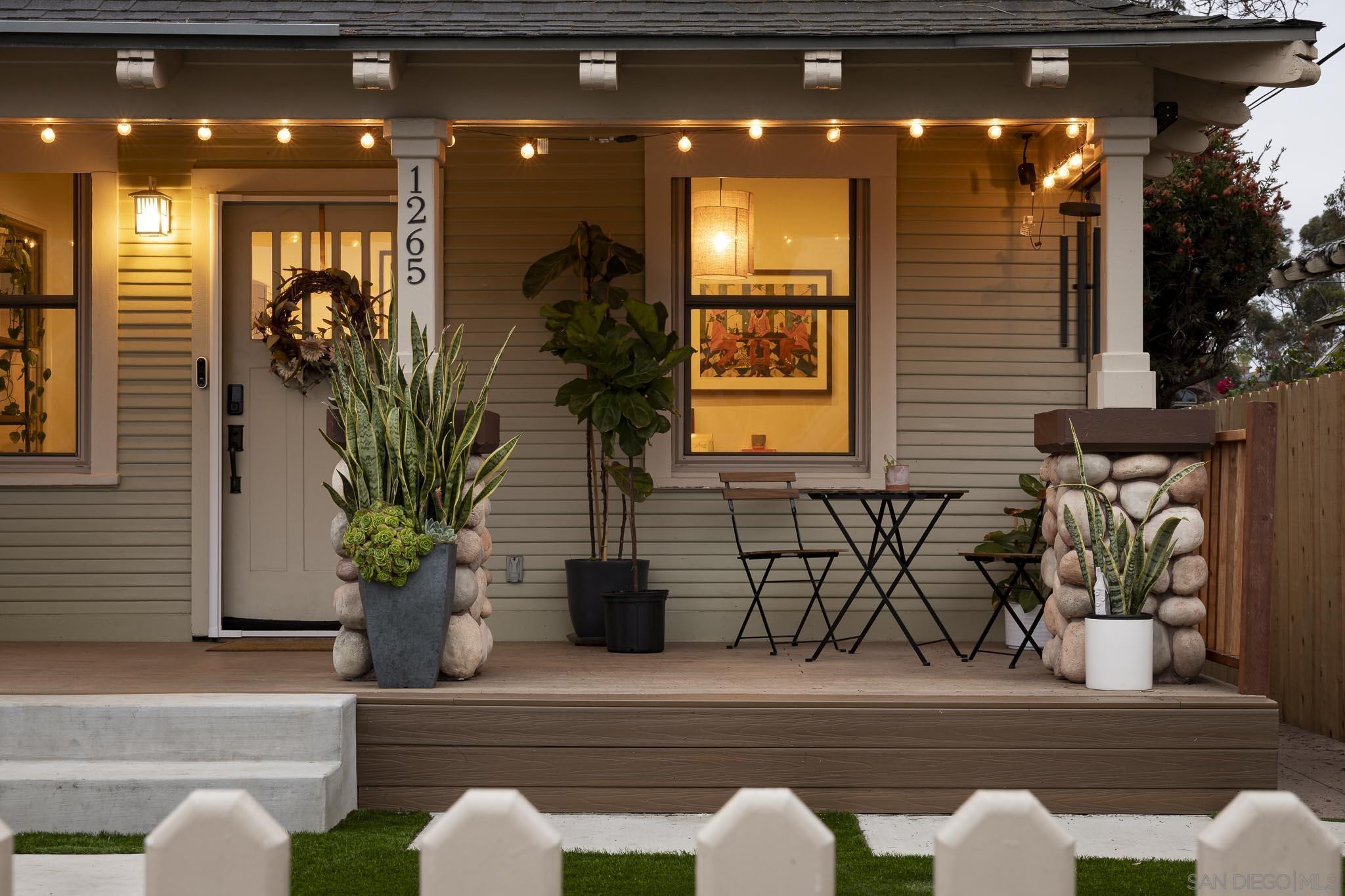 a front view of a house with potted plants