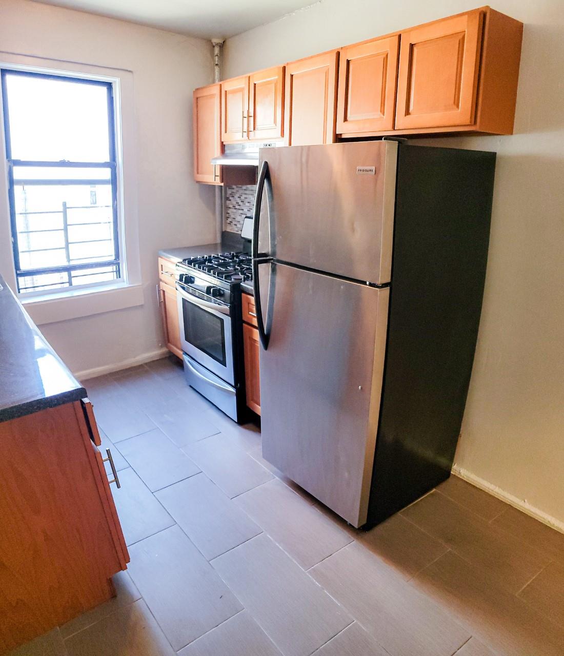 a kitchen with stainless steel appliances a refrigerator and a window