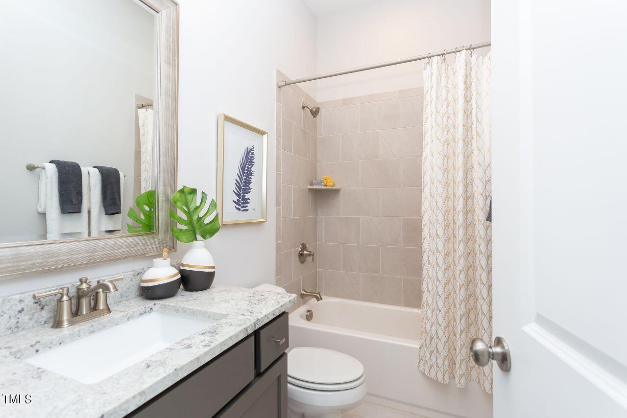 a bathroom with a granite countertop sink a toilet and shower