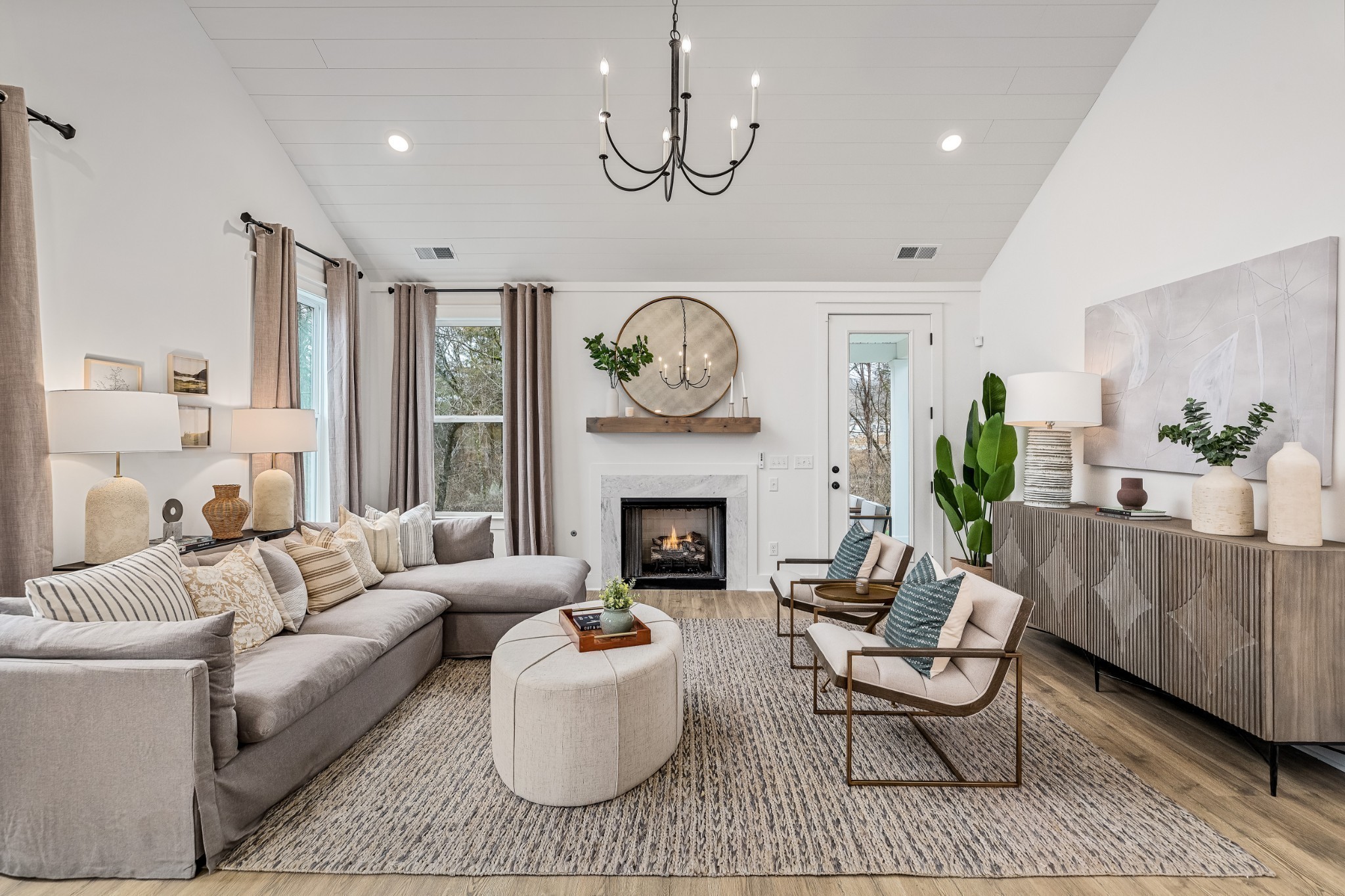 a living room with furniture a fireplace and a chandelier