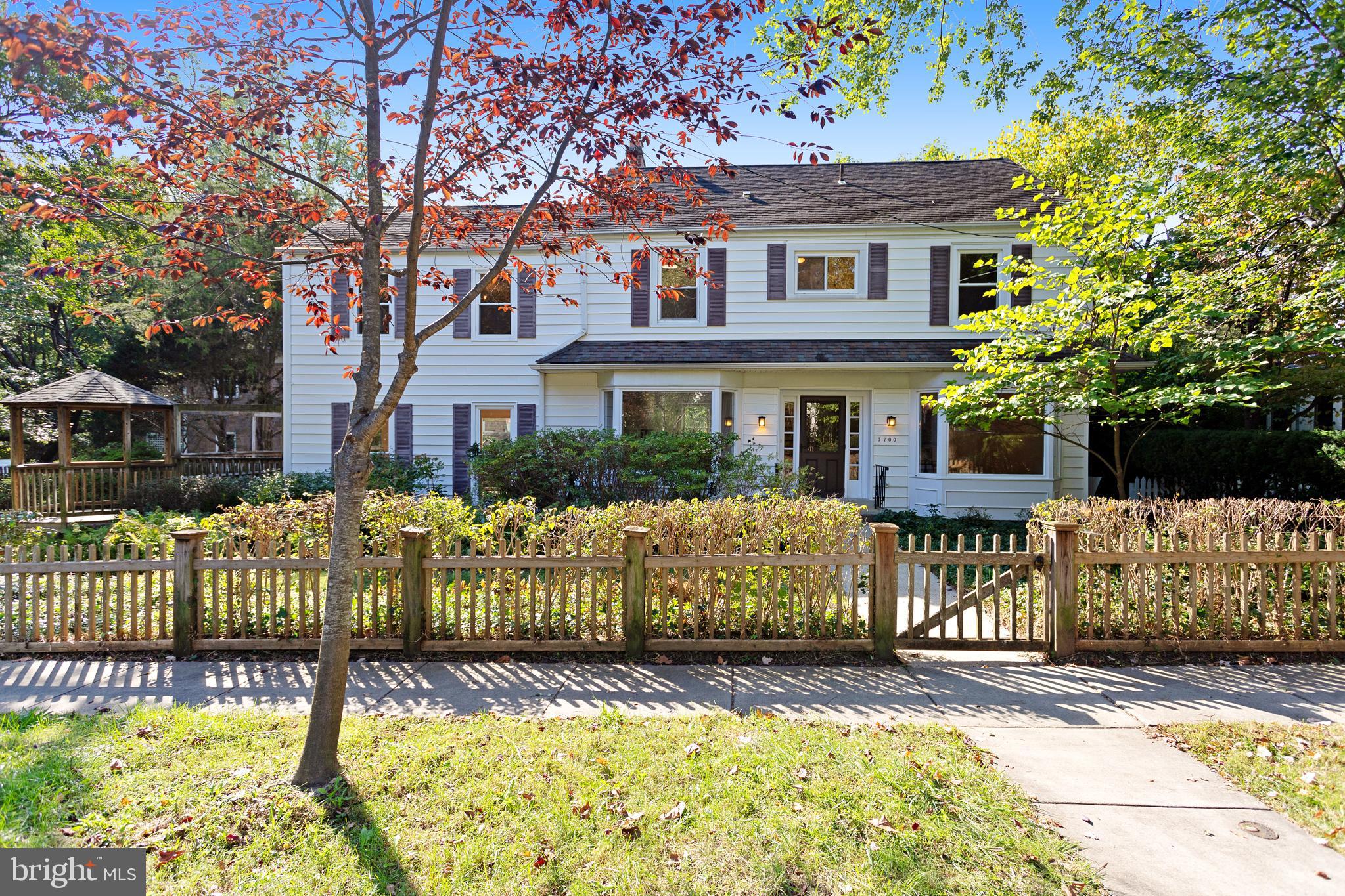 a front view of a house with a fence and a tree