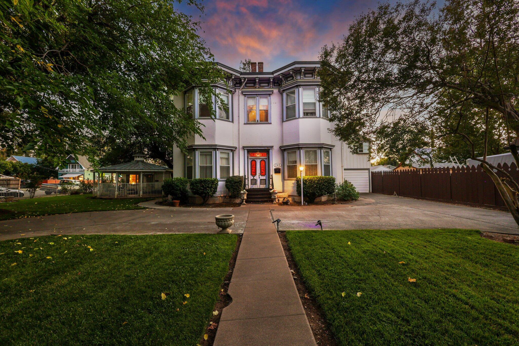 a front view of a house with a yard and potted plants