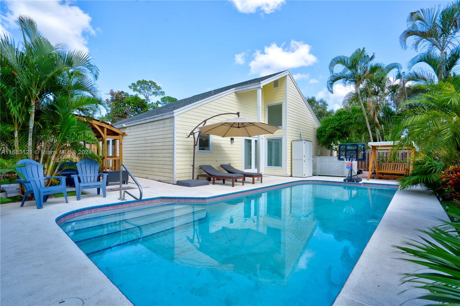 a view of a house with backyard and sitting area