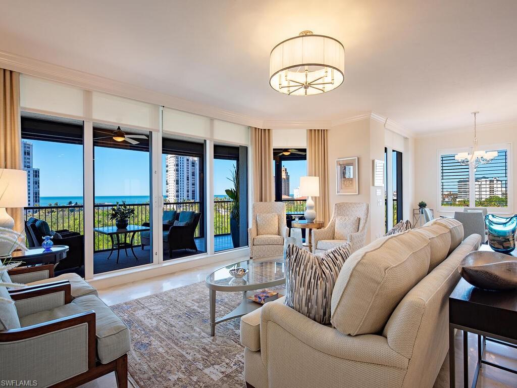 a living room with furniture a lamp and large window