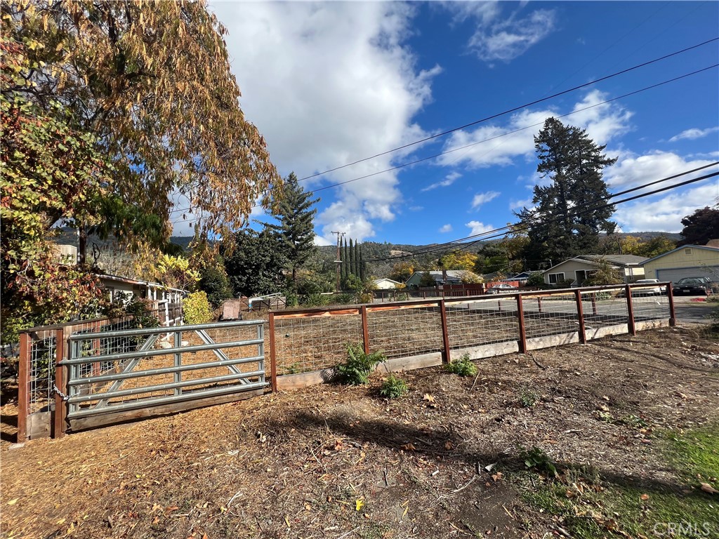 a view of a yard with wooden fence