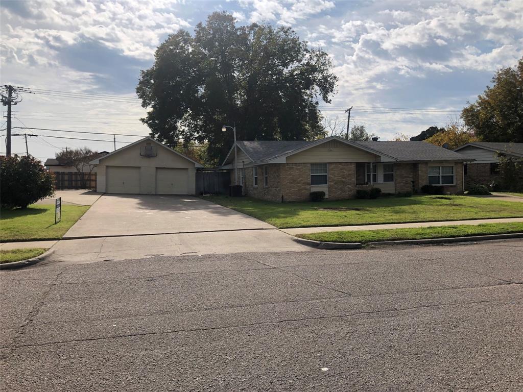 a front view of a house with a yard and trees