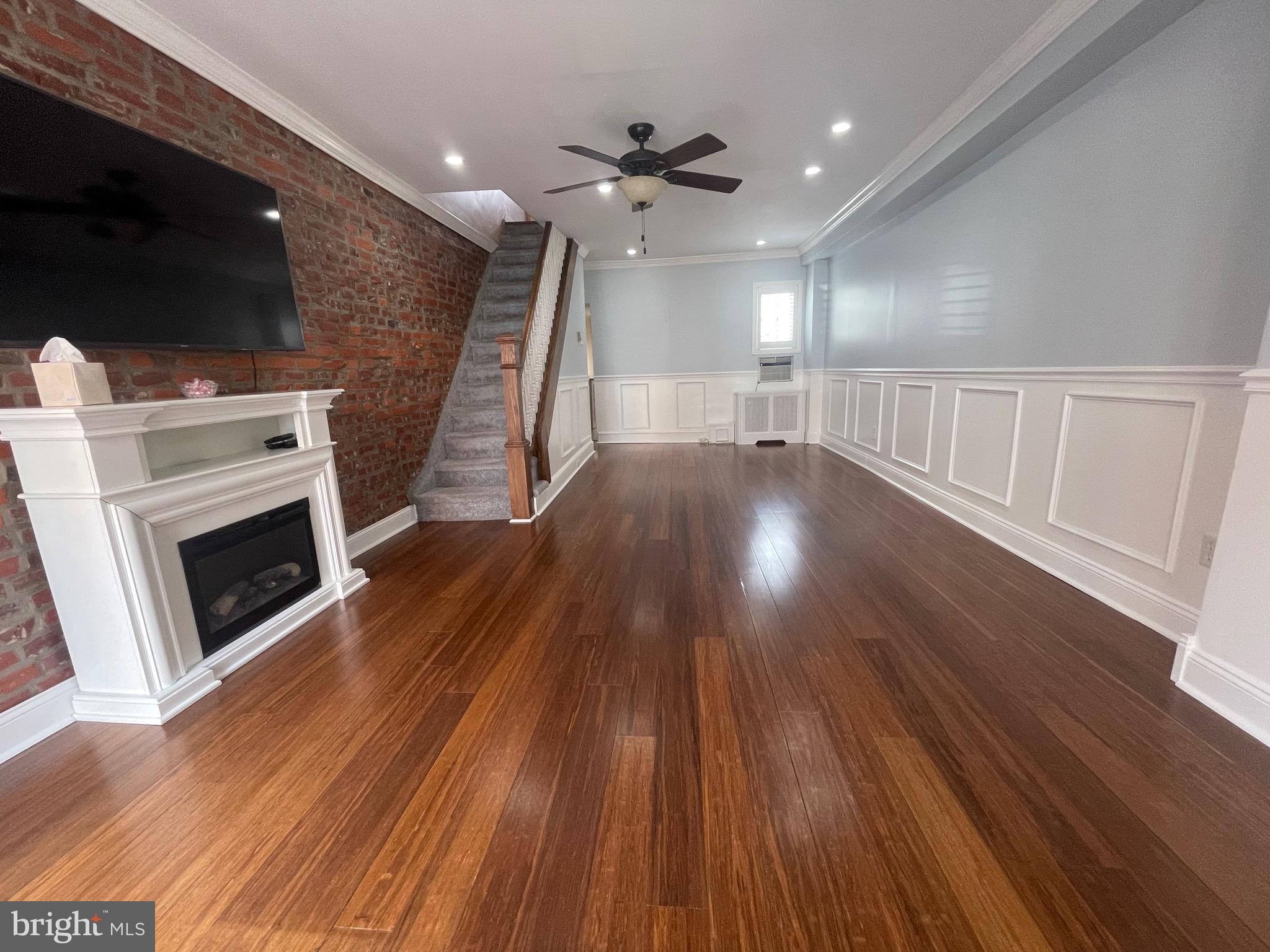 a view of a livingroom with wooden floor and a fireplace