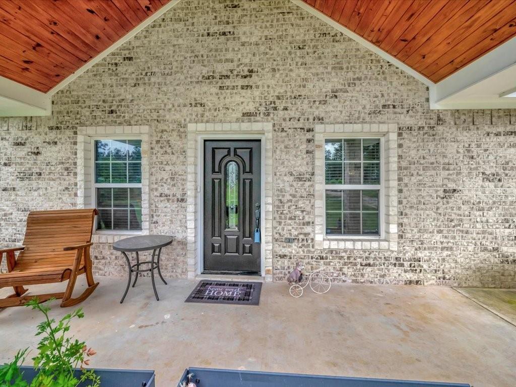 front view of a brick house with a bench in front of it