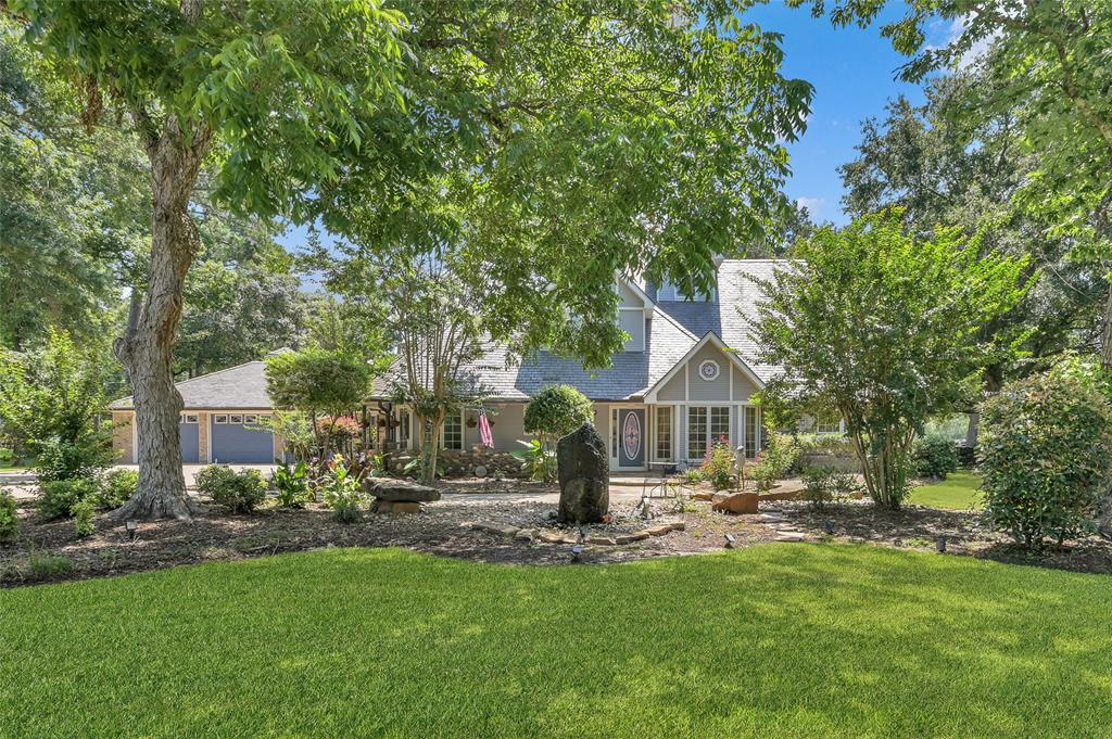 a front view of a house with garden and trees