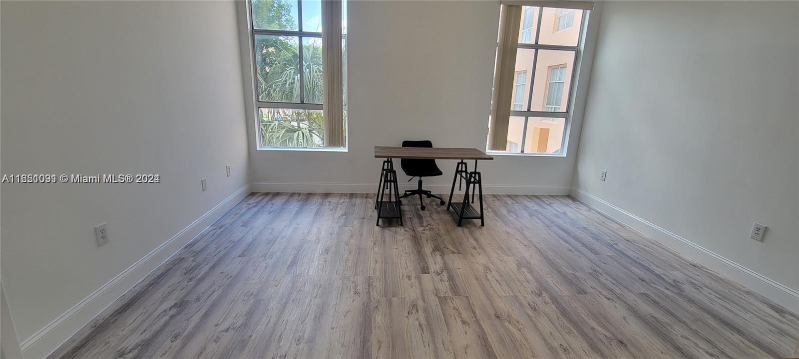 an empty room with wooden floor and a window