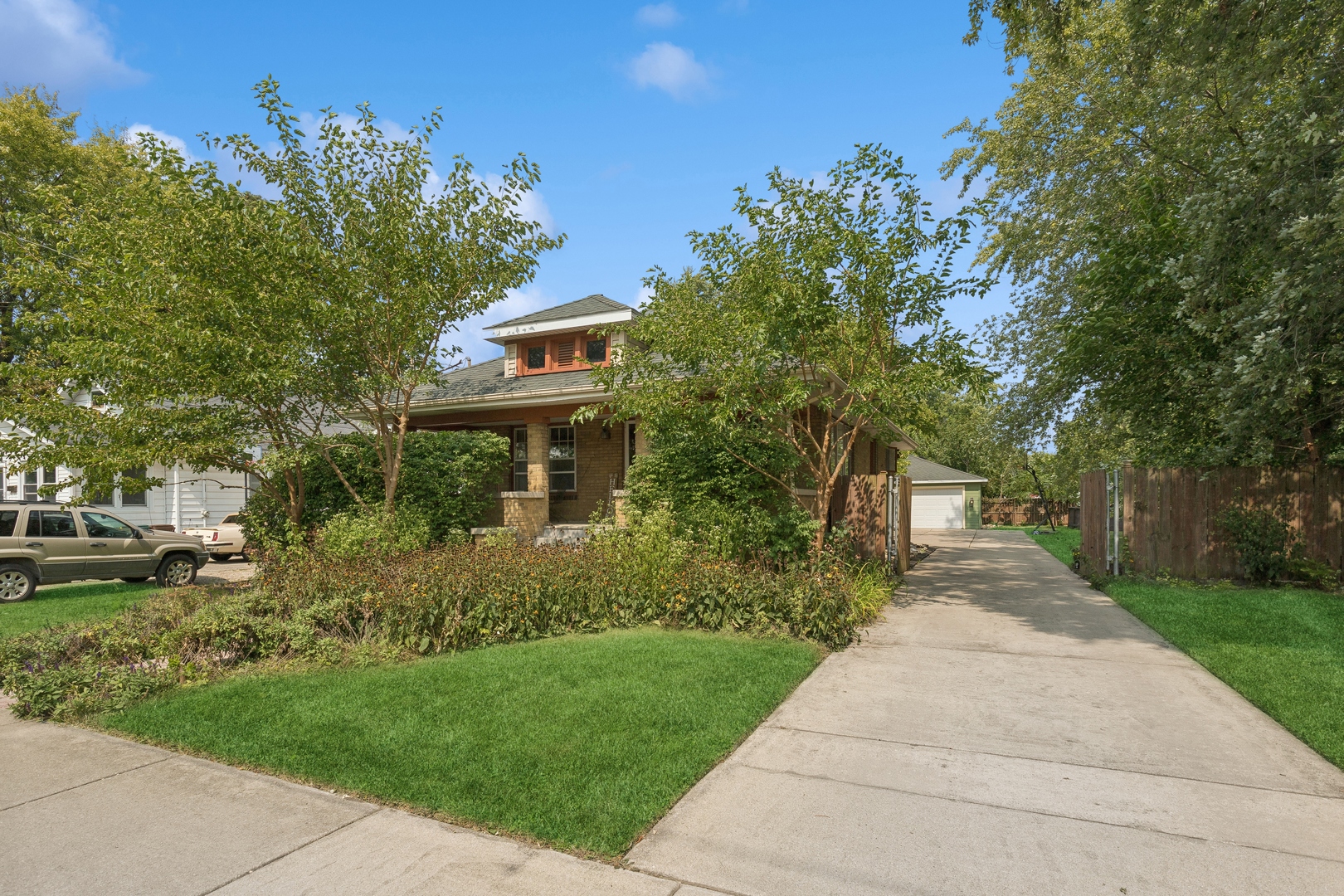 a front view of a house with a yard and trees