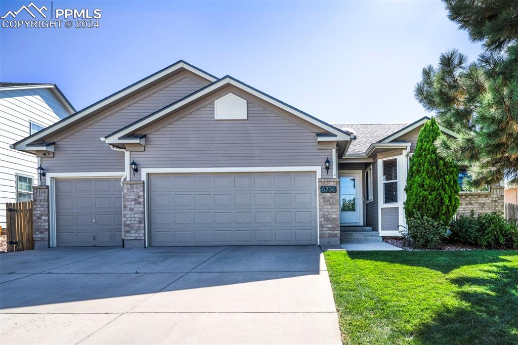 Craftsman-style home featuring a 3 car garage and a front yard