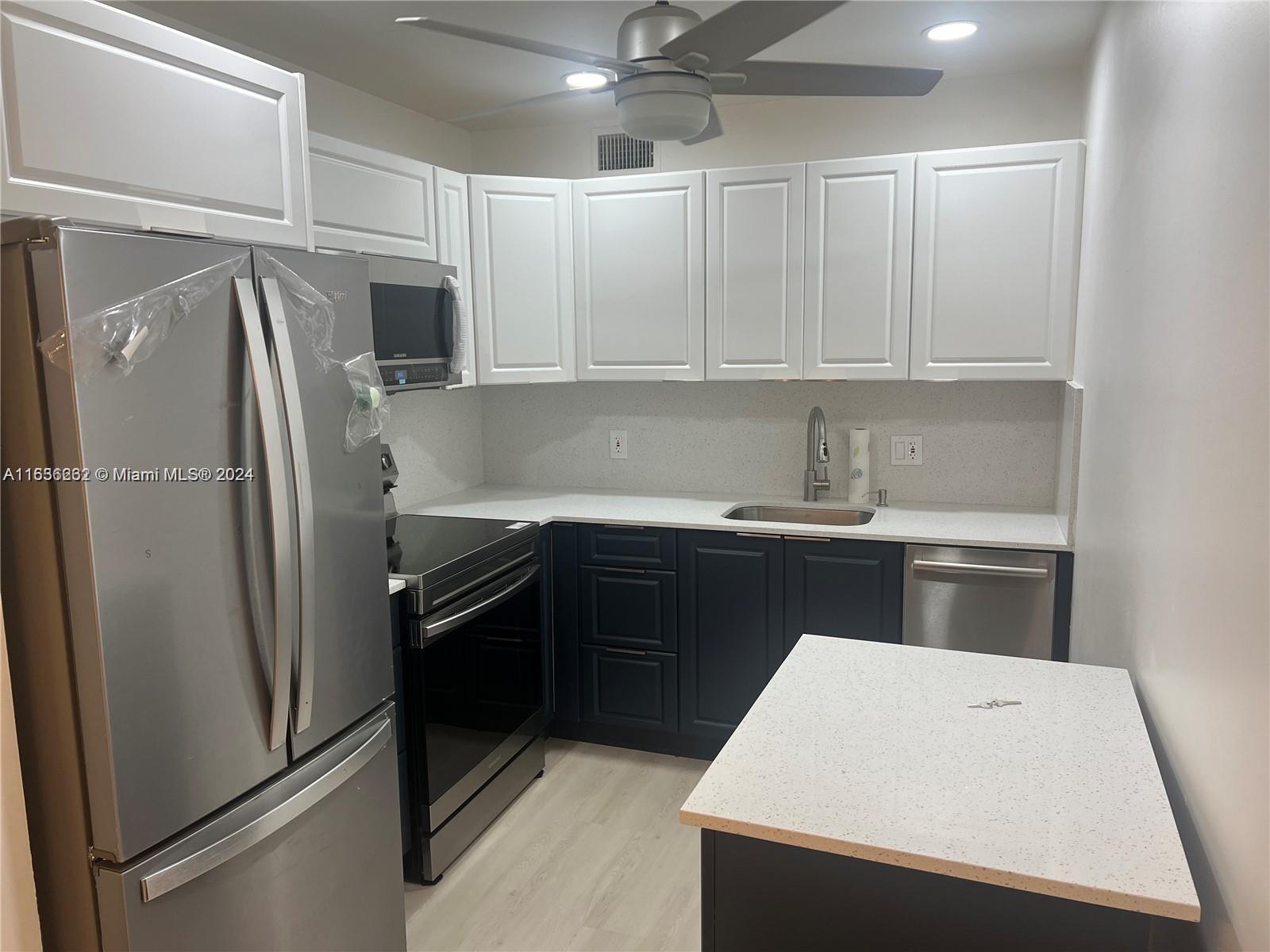 a kitchen with a refrigerator sink and cabinets