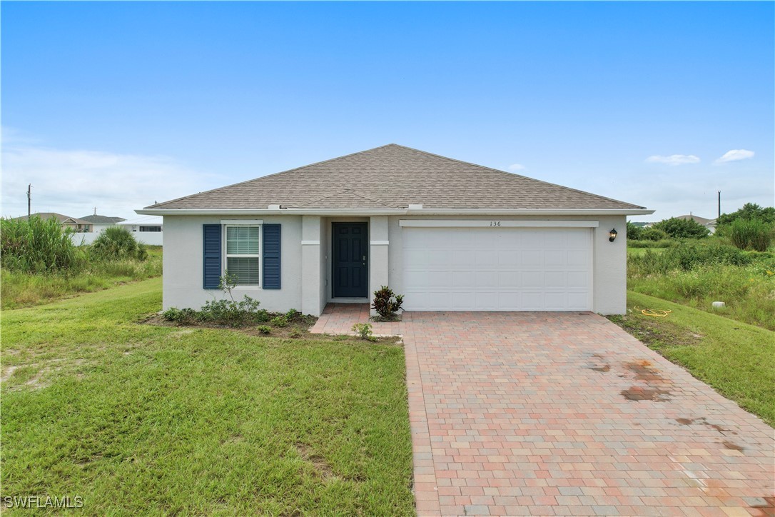 a front view of house with yard and green space