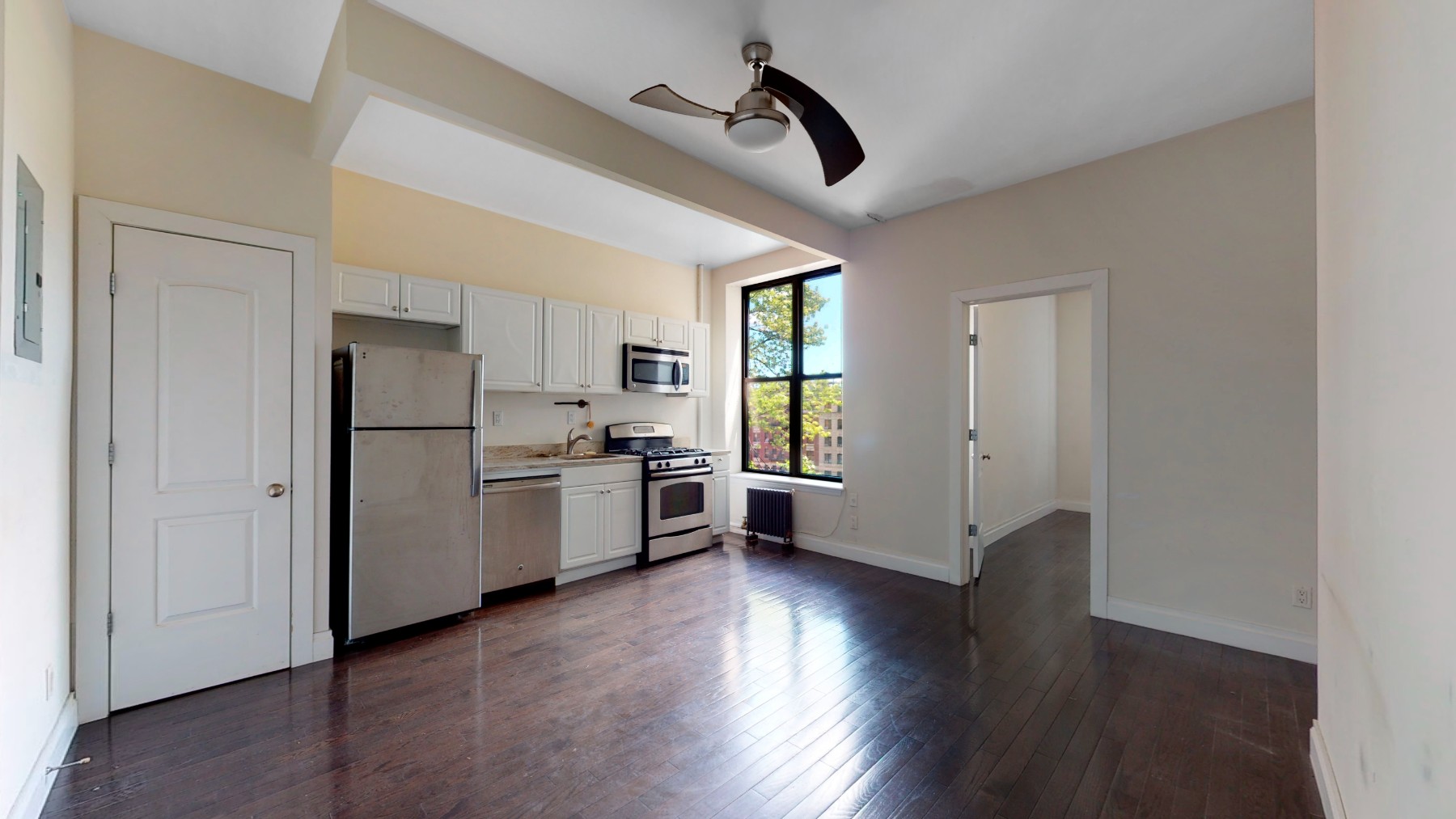 a kitchen with stainless steel appliances a refrigerator and a hard wood floor