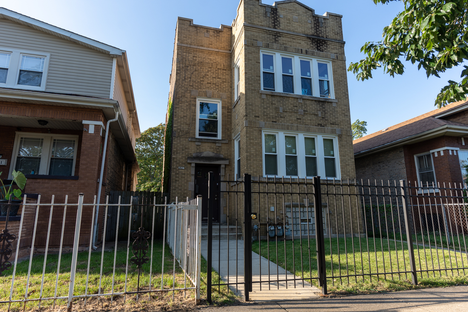 a view of a brick house in front of a yard