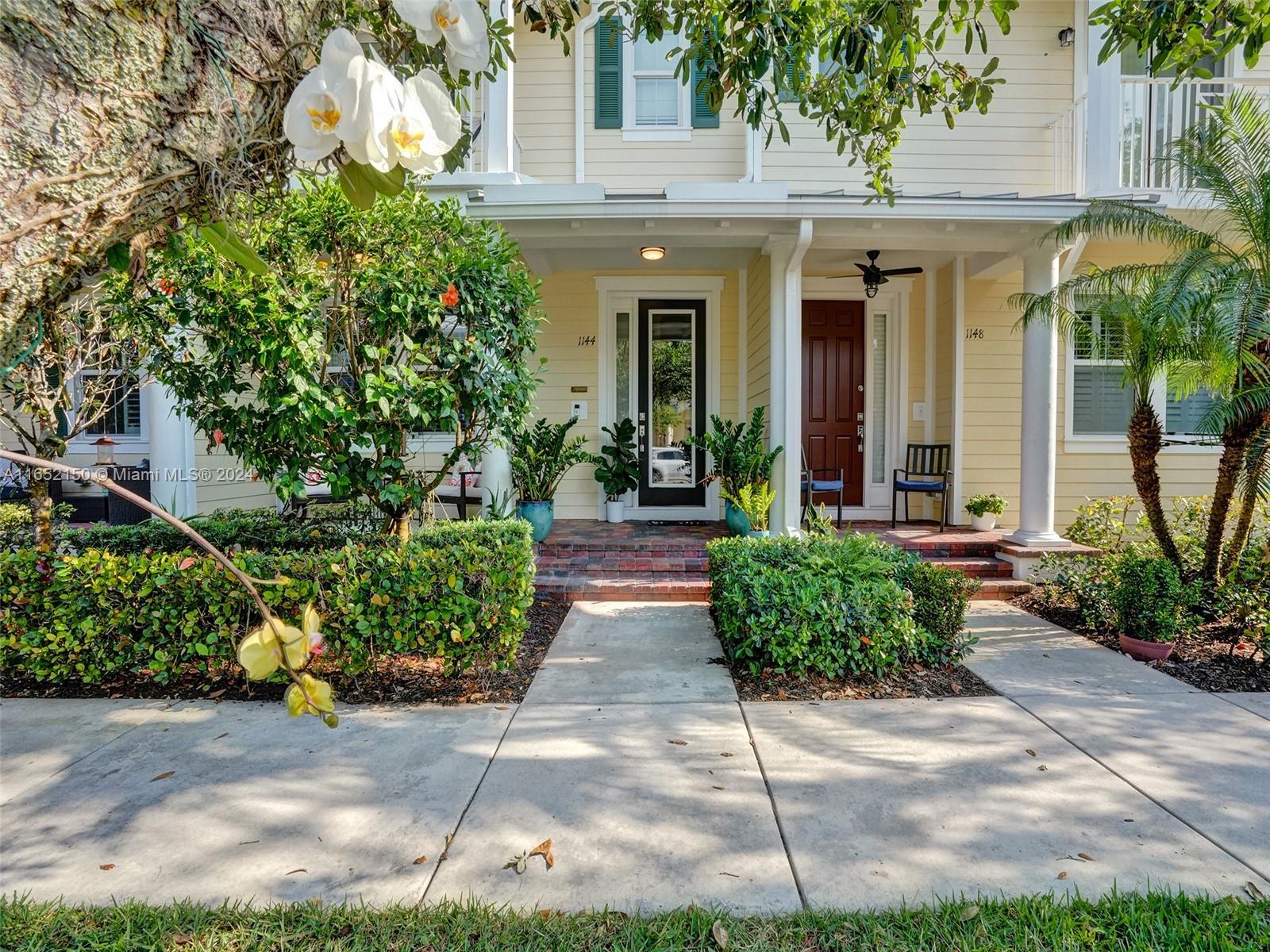 a view of a house with potted plants and a fountain