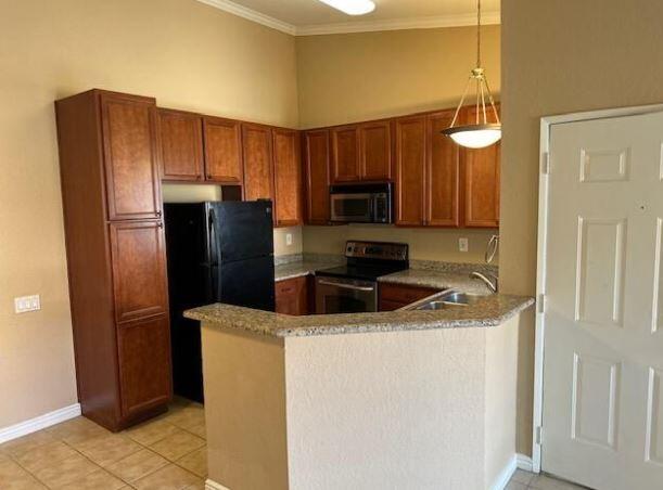 a kitchen with stainless steel appliances granite countertop a refrigerator a stove and a sink with wooden cabinets