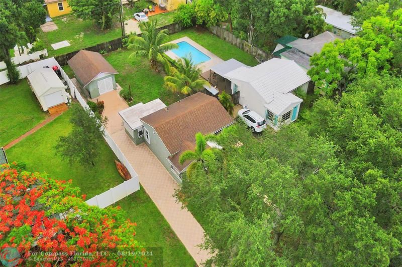 an aerial view of residential house with outdoor space and trees all around