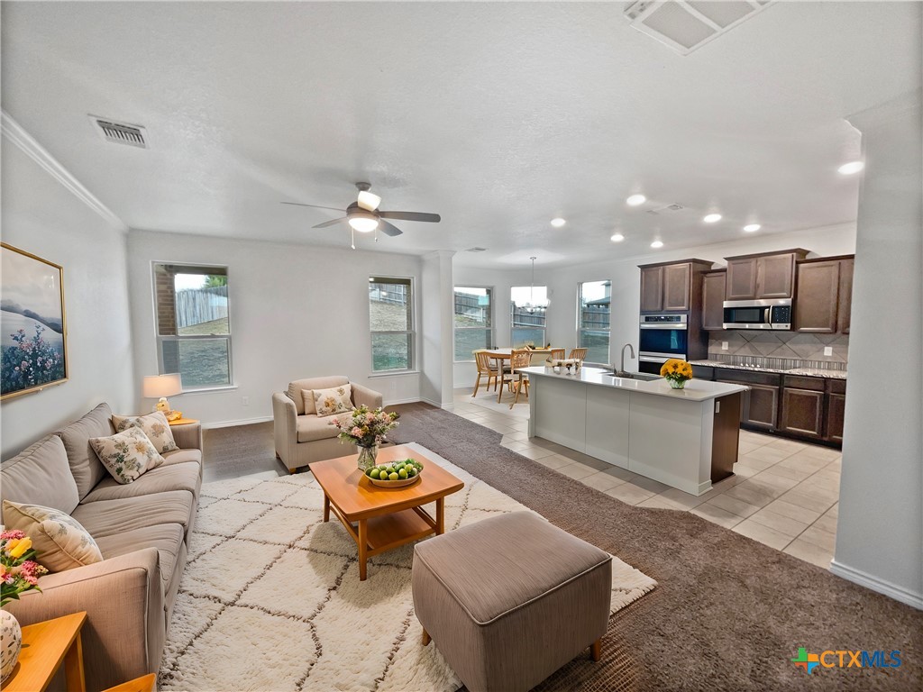 a living room with furniture and kitchen view