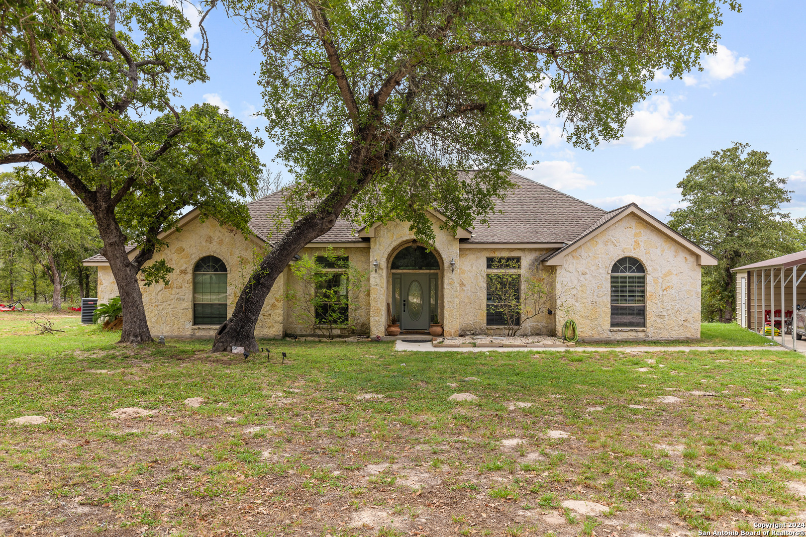 a large house with a big yard and large trees