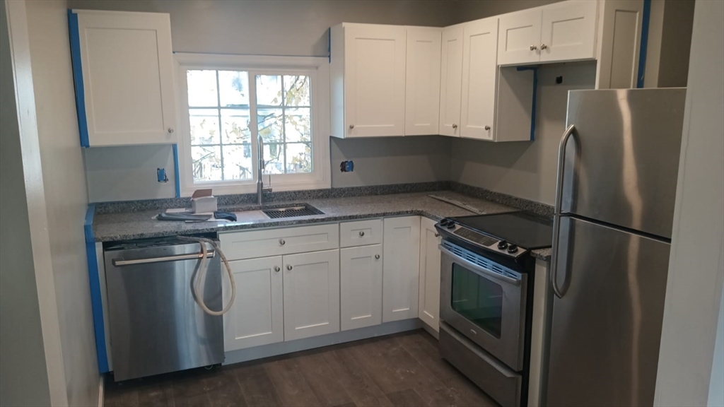 a kitchen with stainless steel appliances granite countertop a refrigerator sink and stove