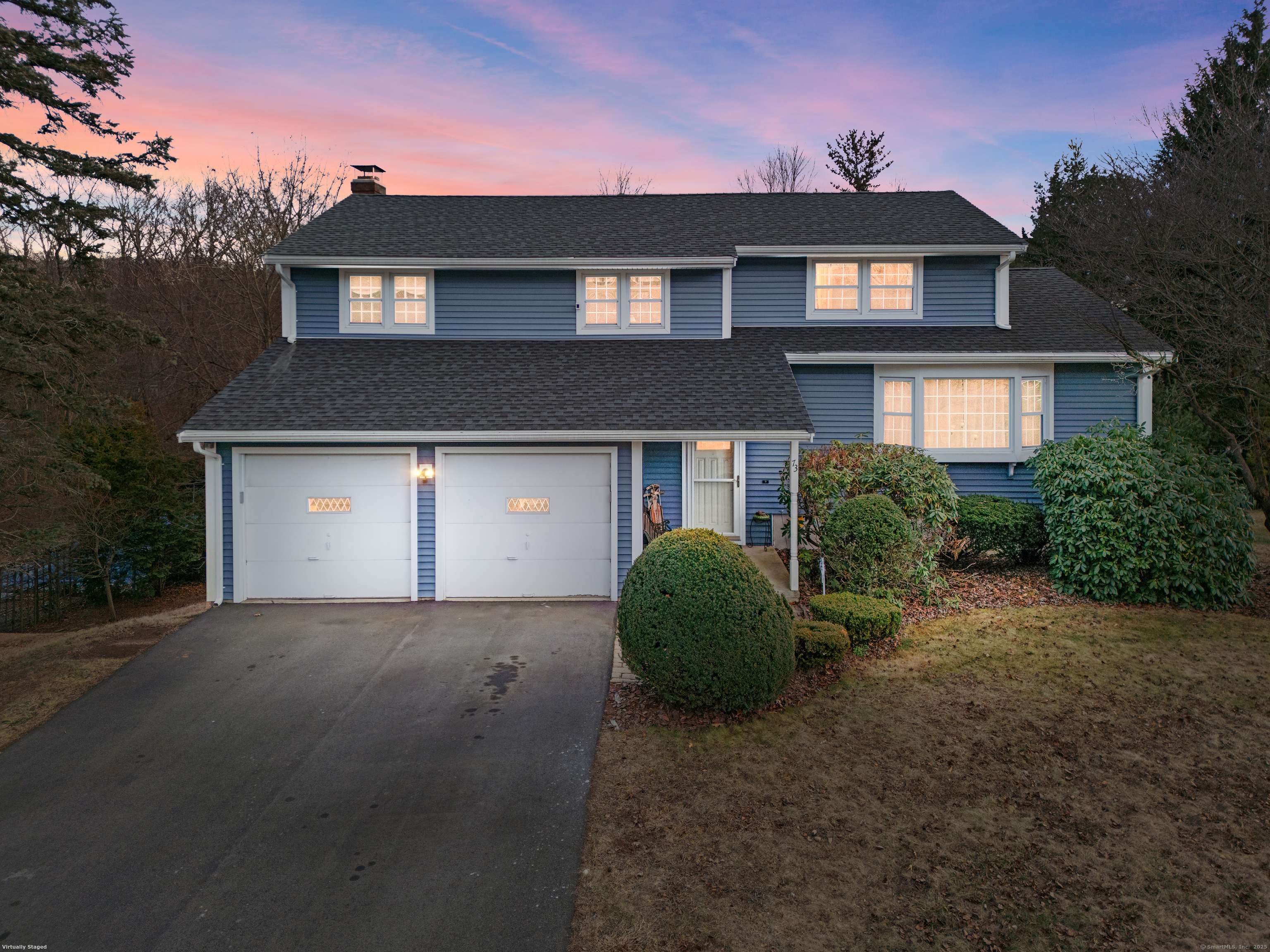 a front view of a house with a garden and garage