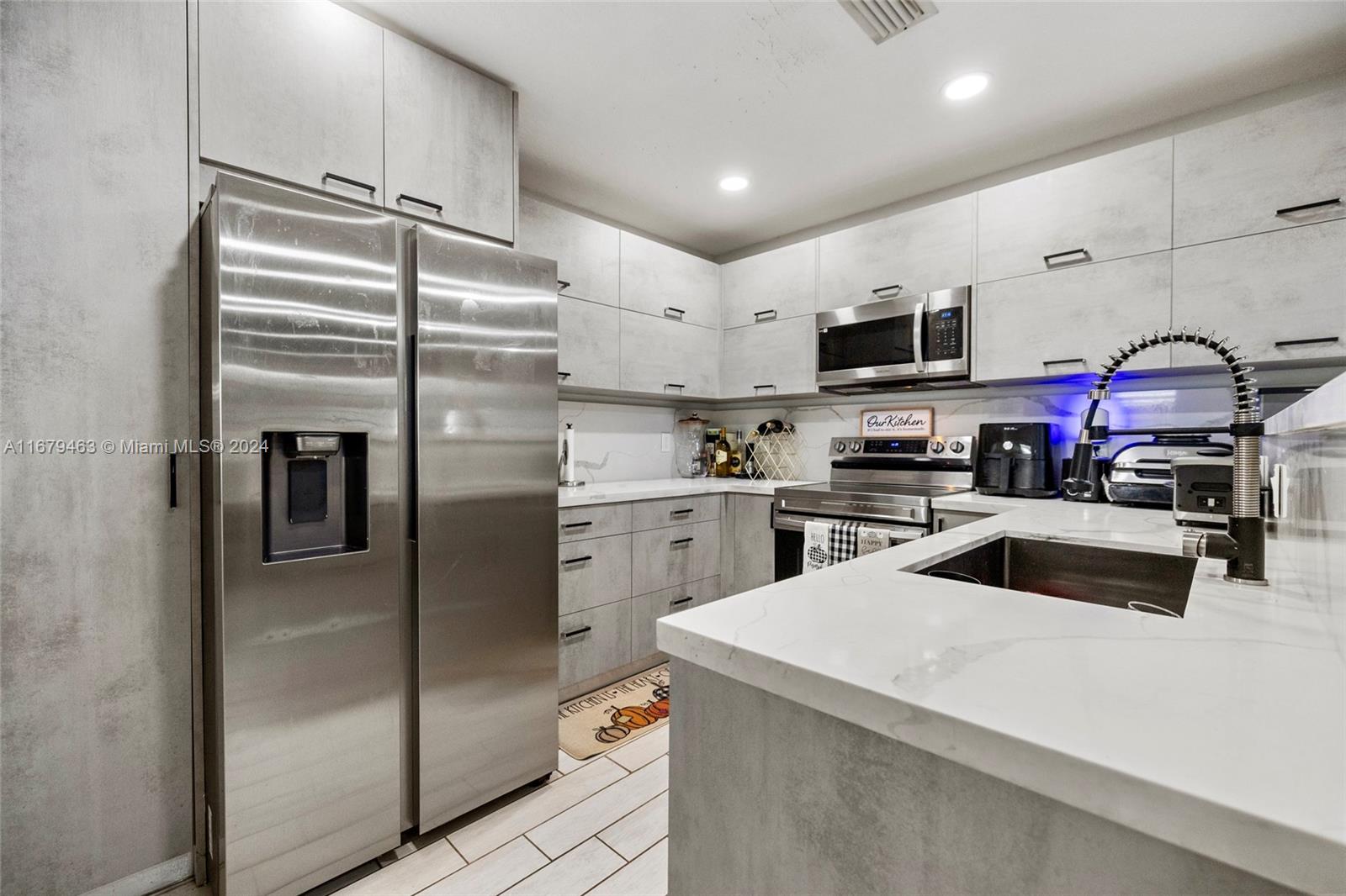 a kitchen with kitchen island a counter top space stainless steel appliances and cabinets