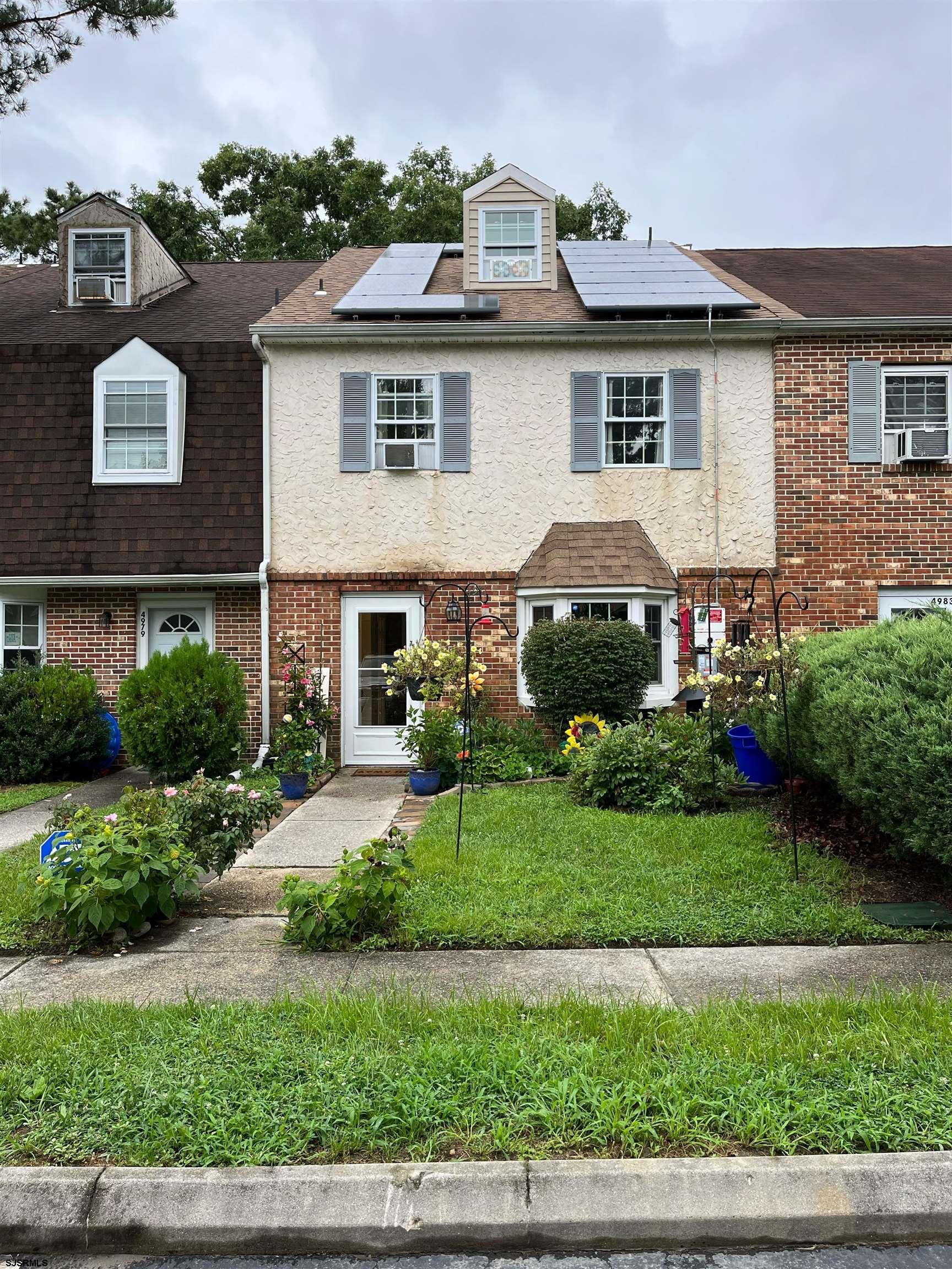 a front view of a house with a garden