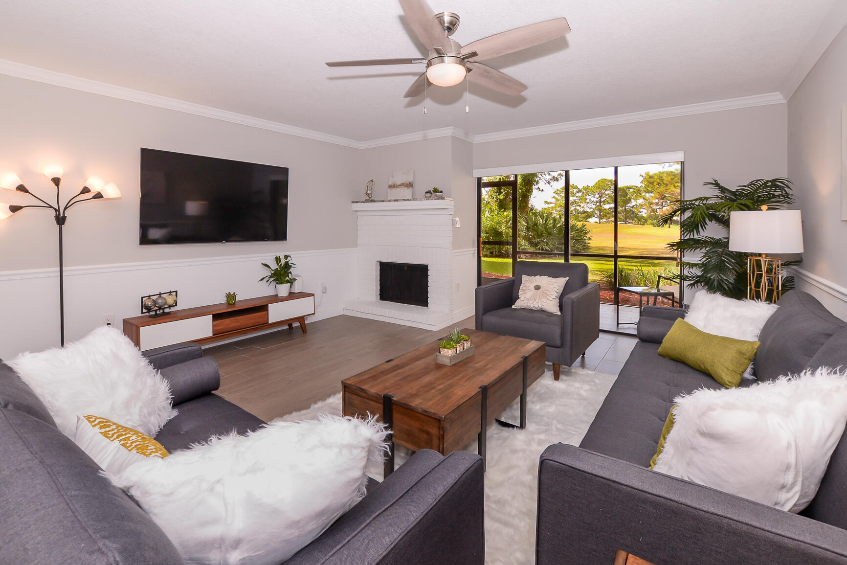 a living room with furniture flat screen tv and a large window