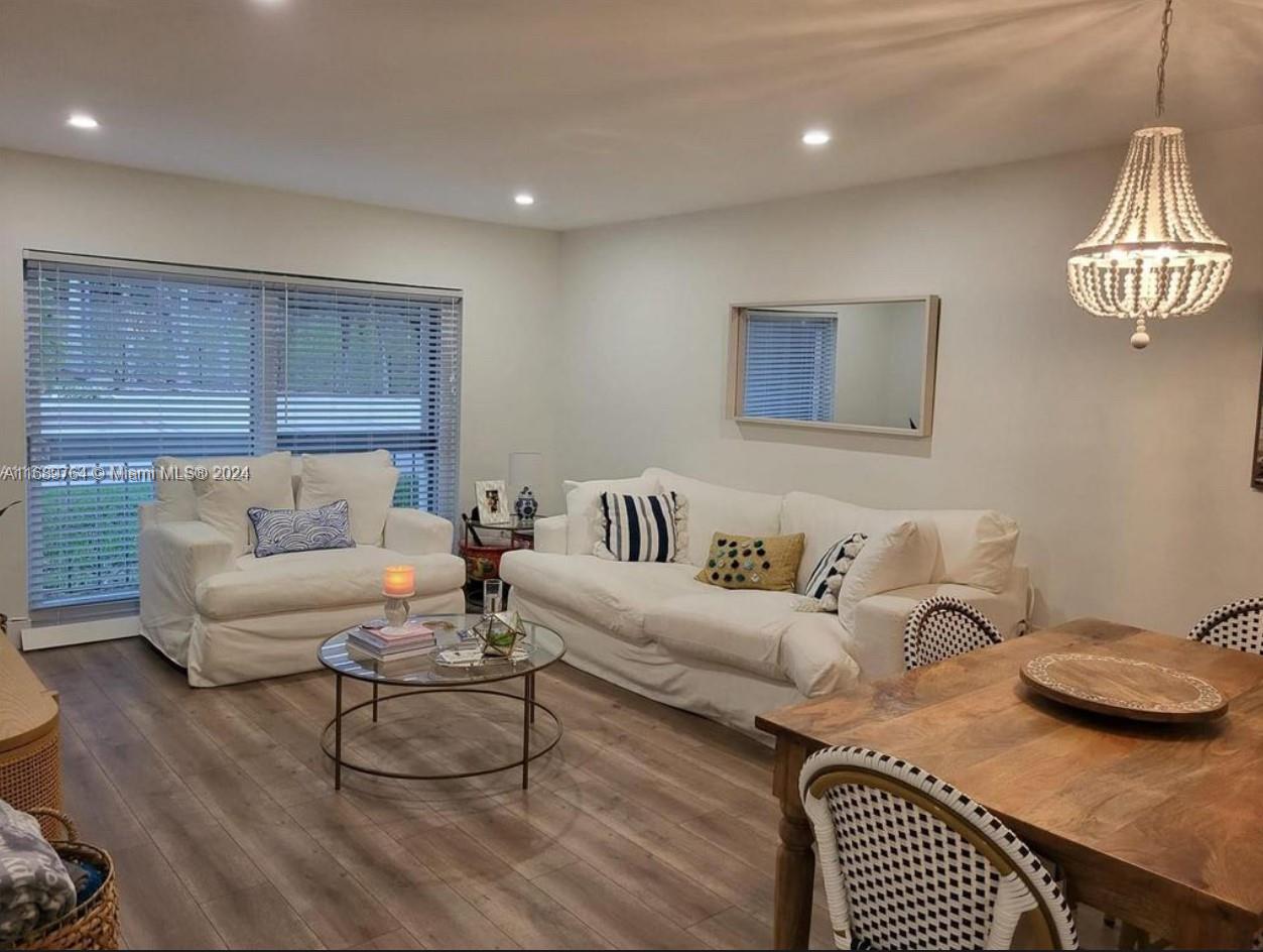 a living room with furniture a rug and kitchen view