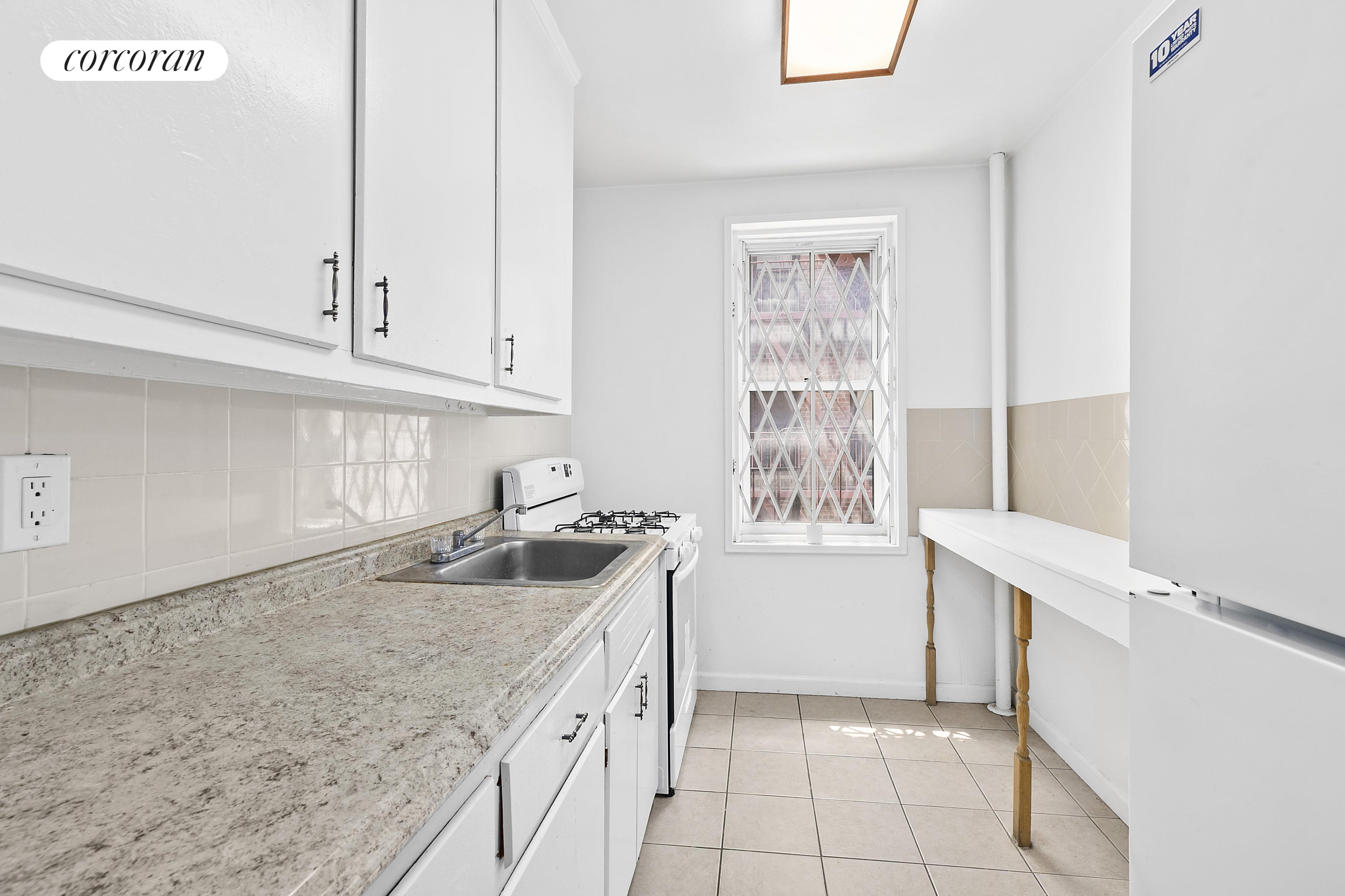 a kitchen with granite countertop a sink a stove and cabinets