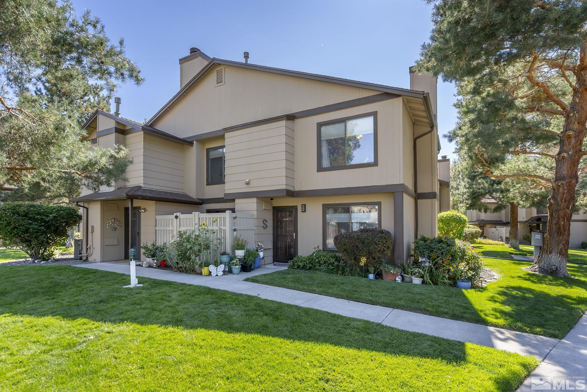 a front view of a house with a garden and plants