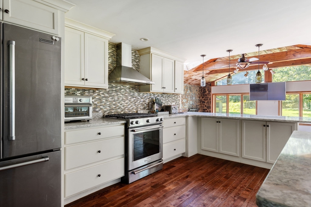 a kitchen with stainless steel appliances white cabinets and wooden floors