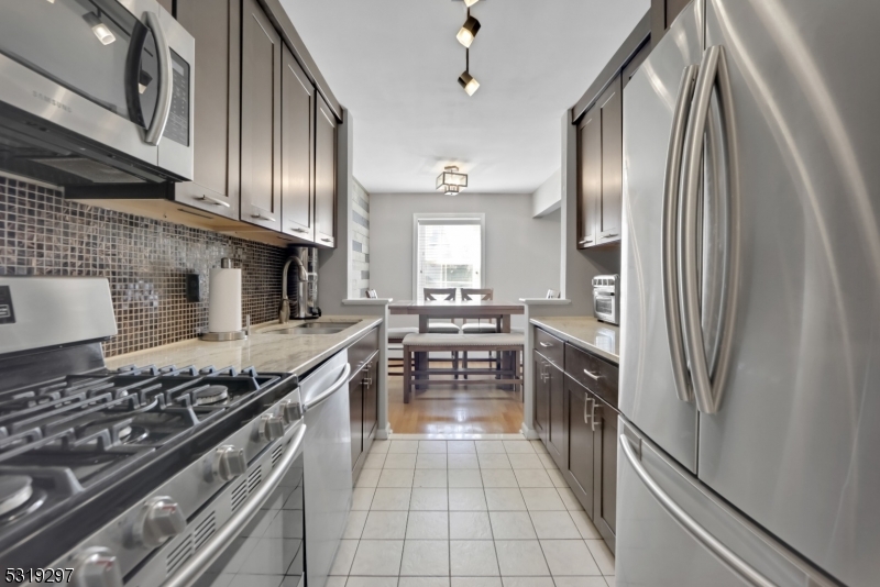 a kitchen with stainless steel appliances granite countertop a stove top oven a sink and dishwasher