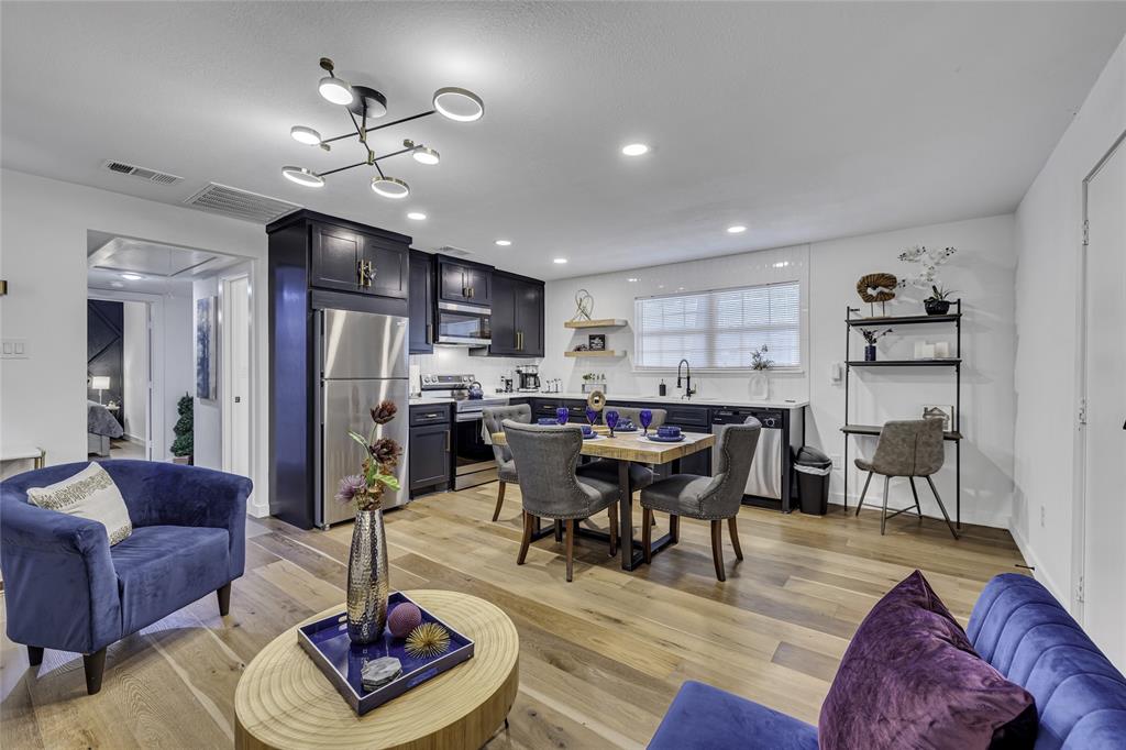 a living room with furniture kitchen view and a chandelier