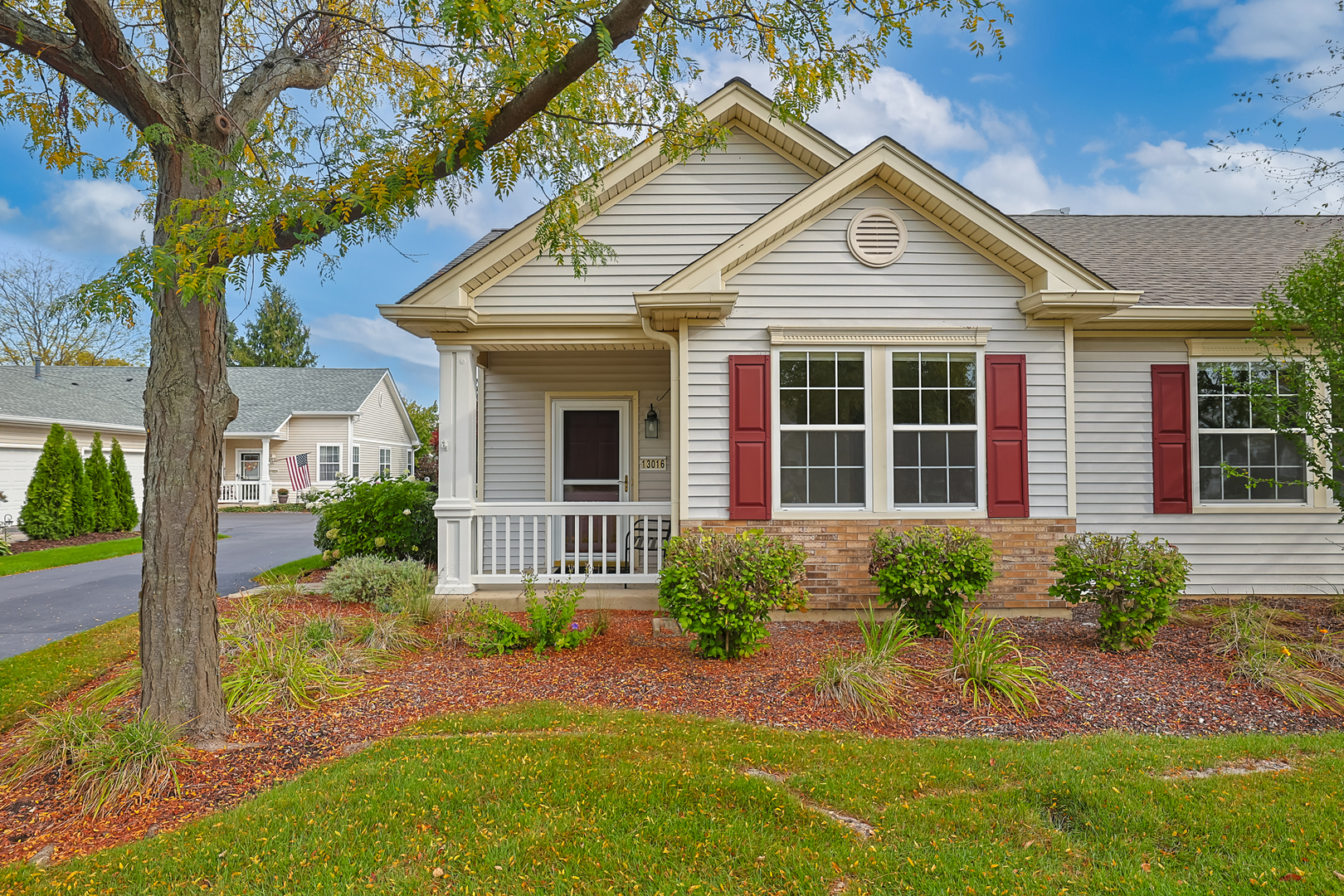 a front view of a house with a yard and potted plants