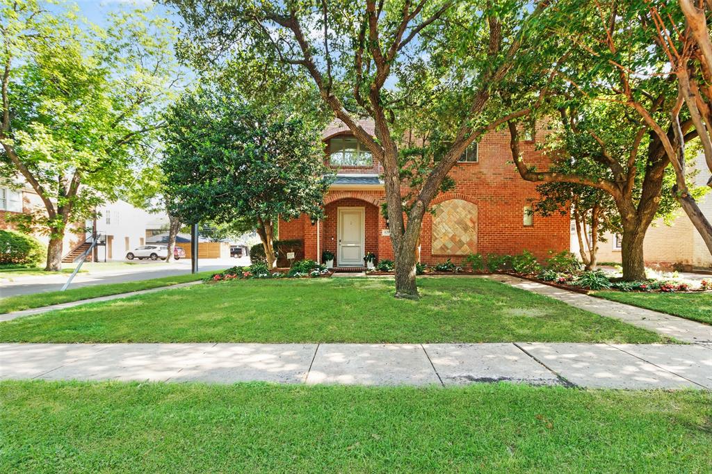 a front view of a house with a yard and fountain