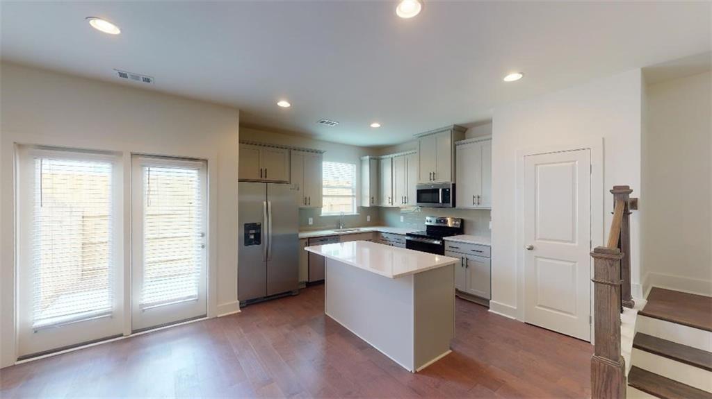 a kitchen with stainless steel appliances granite countertop a refrigerator and a stove top oven