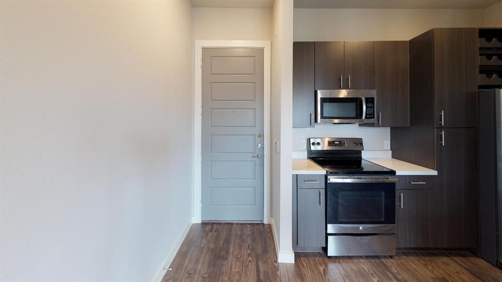 a kitchen with a refrigerator and a stove top oven