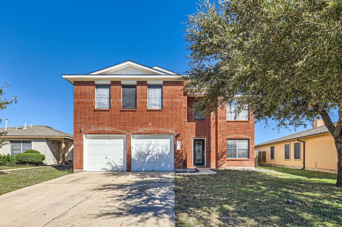 a front view of a house with a yard and garage