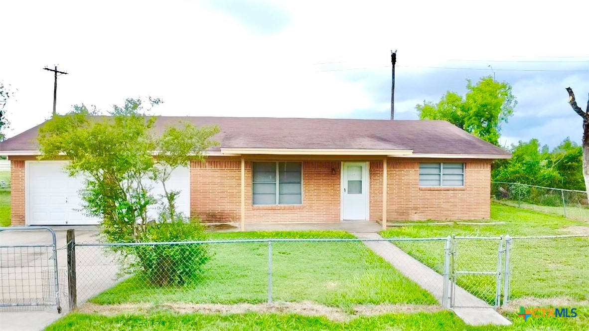 a front view of a house with a yard and potted plants