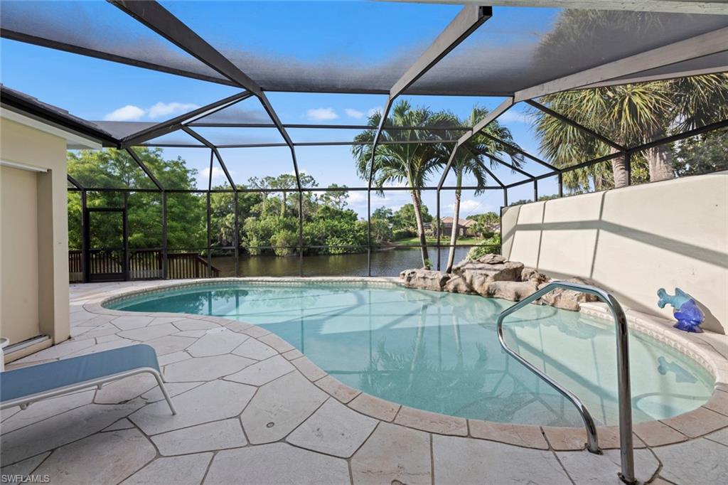 View of swimming pool featuring glass enclosure and a patio