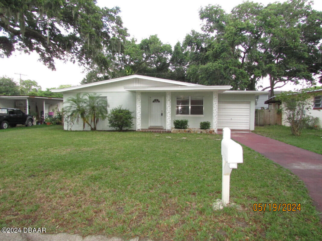 a front view of house with yard and green space