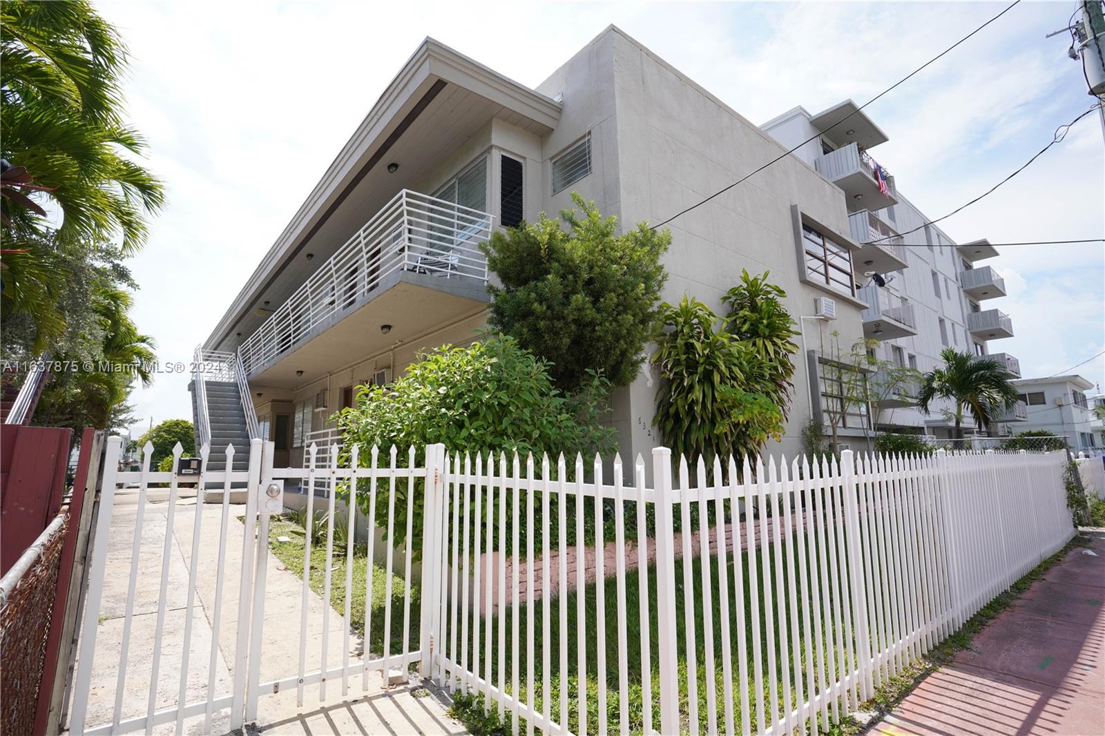 a view of a brick house with wooden fence